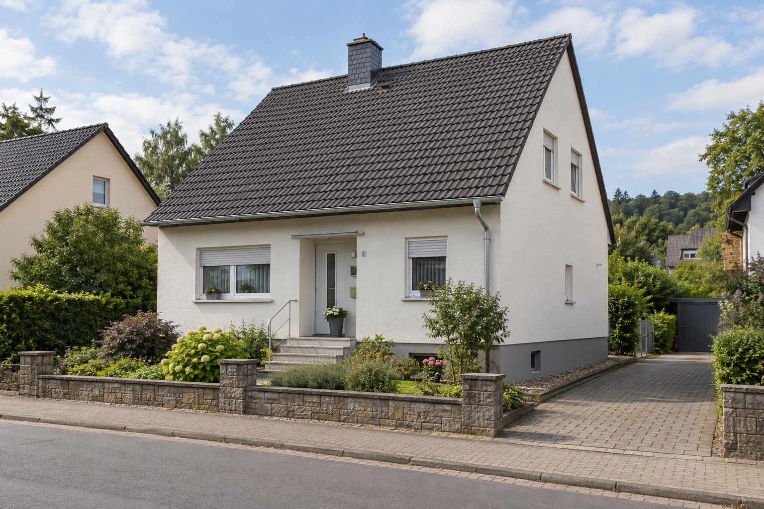 Einfamilienhaus mit Satteldach, heller Putzfassade und kleinem Vorgarten